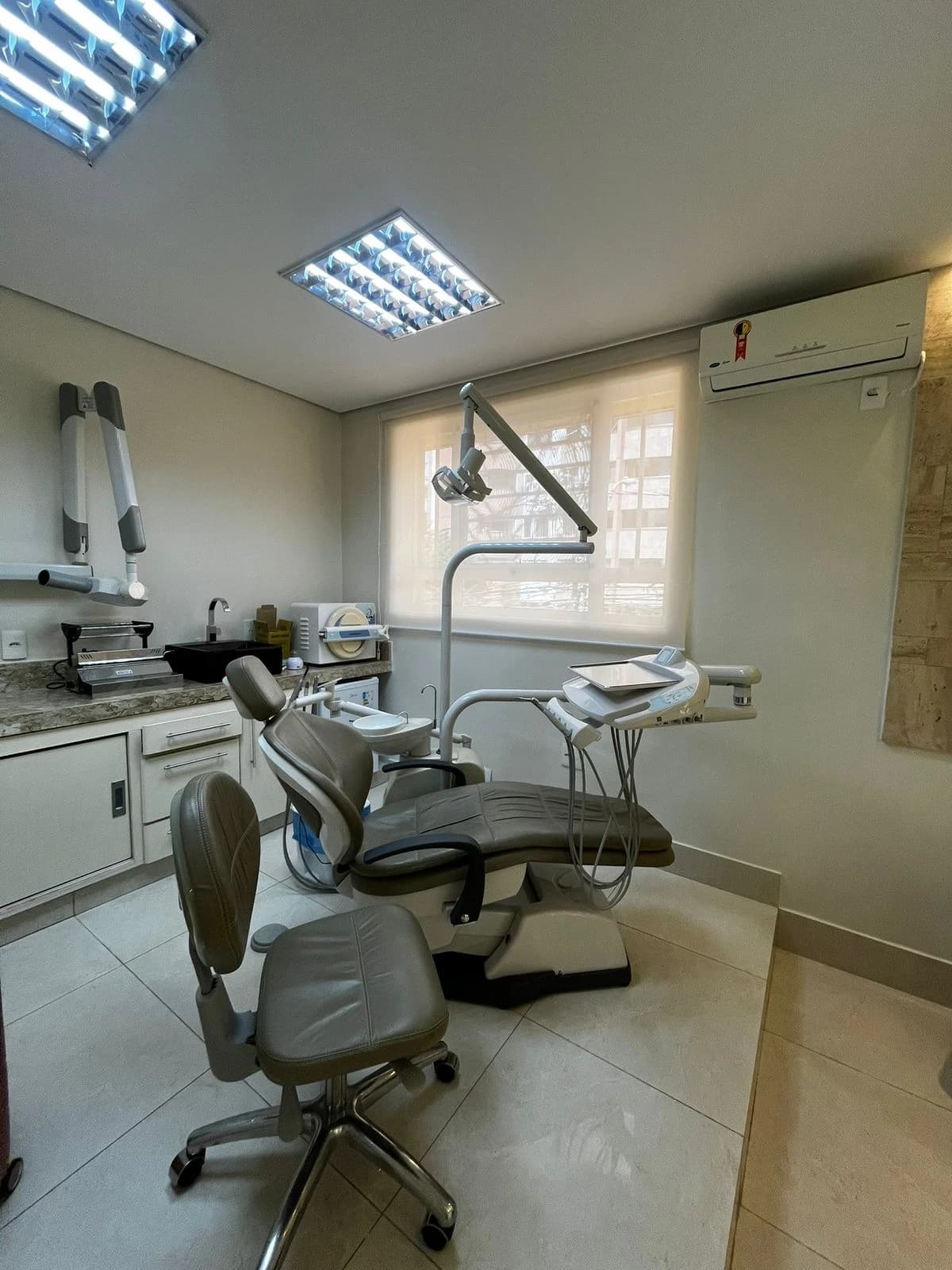 Consultório da Dra. Jéssica Enes com cadeira odontológica e microscopia
